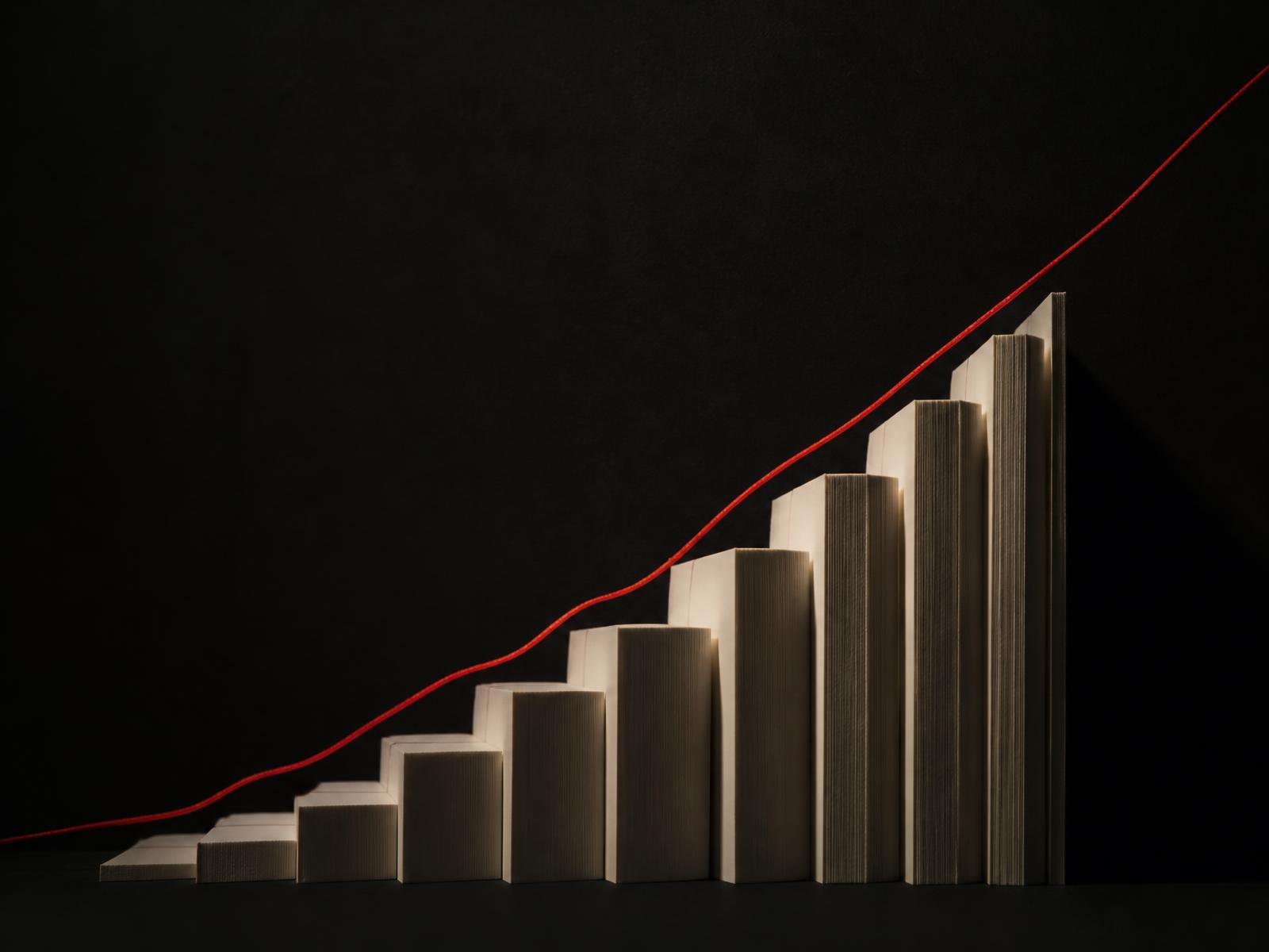 Cream paper blocks rising in a stepped formation against a near-black backdrop, traced by a thin red ascending line